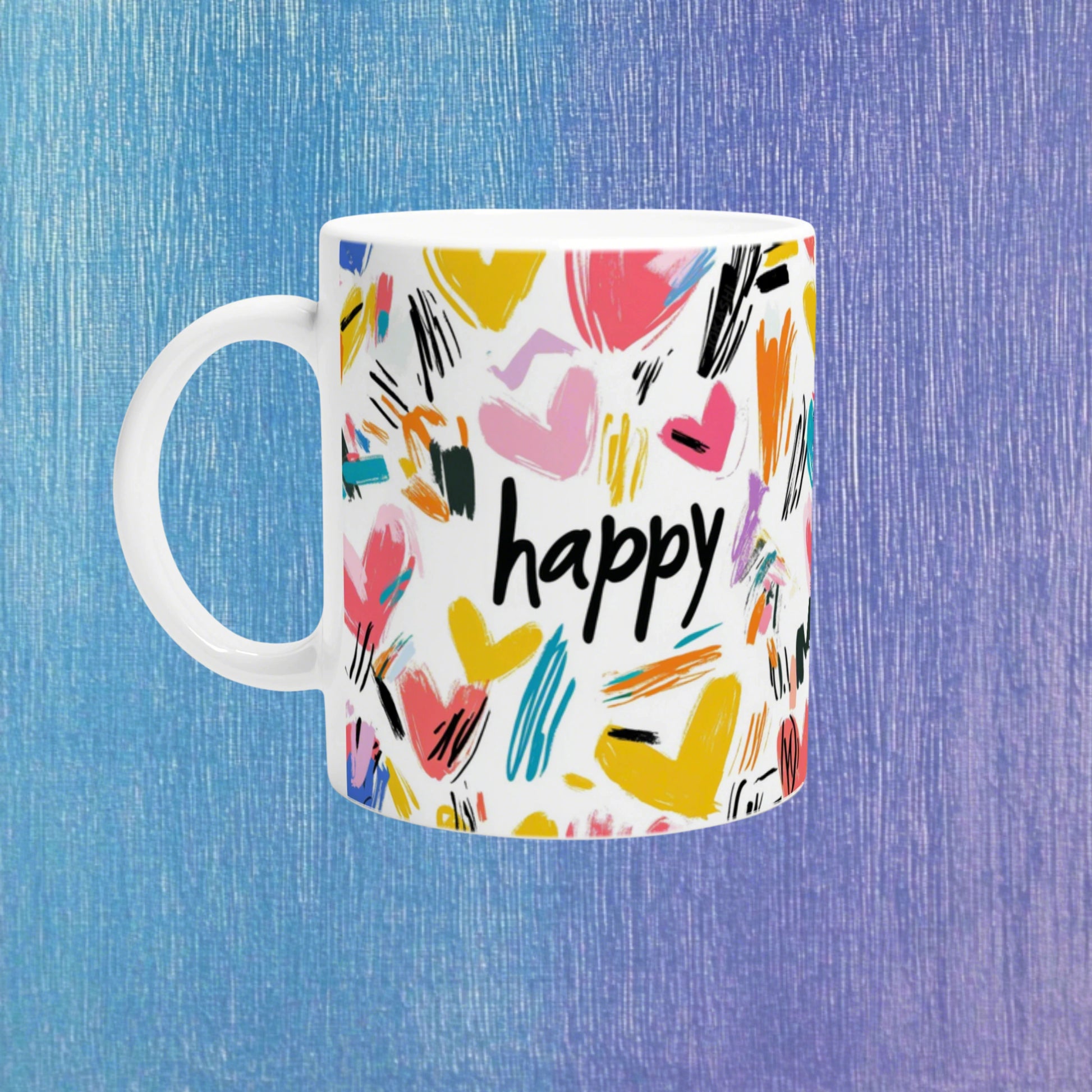 White mug with colorful abstract brushstrokes and the word happy in black, against a blue textured background.