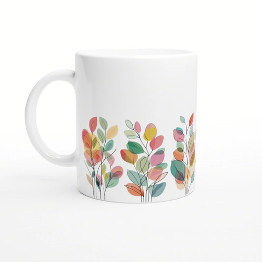 White ceramic mug featuring a colorful abstract leaf pattern along the bottom edge.