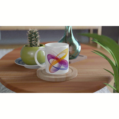 White mug with a colorful abstract swirl design on a wooden table, with a cactus and decorative vase in the background.