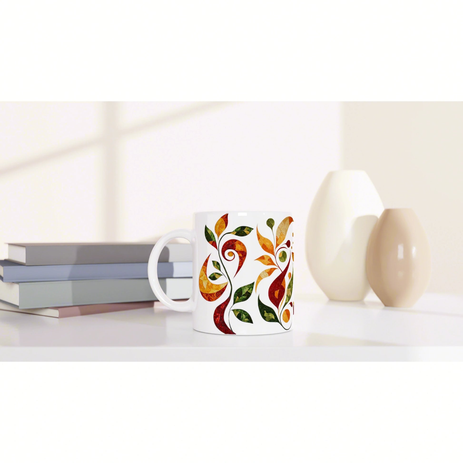 Product mockup: white mug with a colorful orange-green leaf pattern, placed beside books and vases on a light desk.