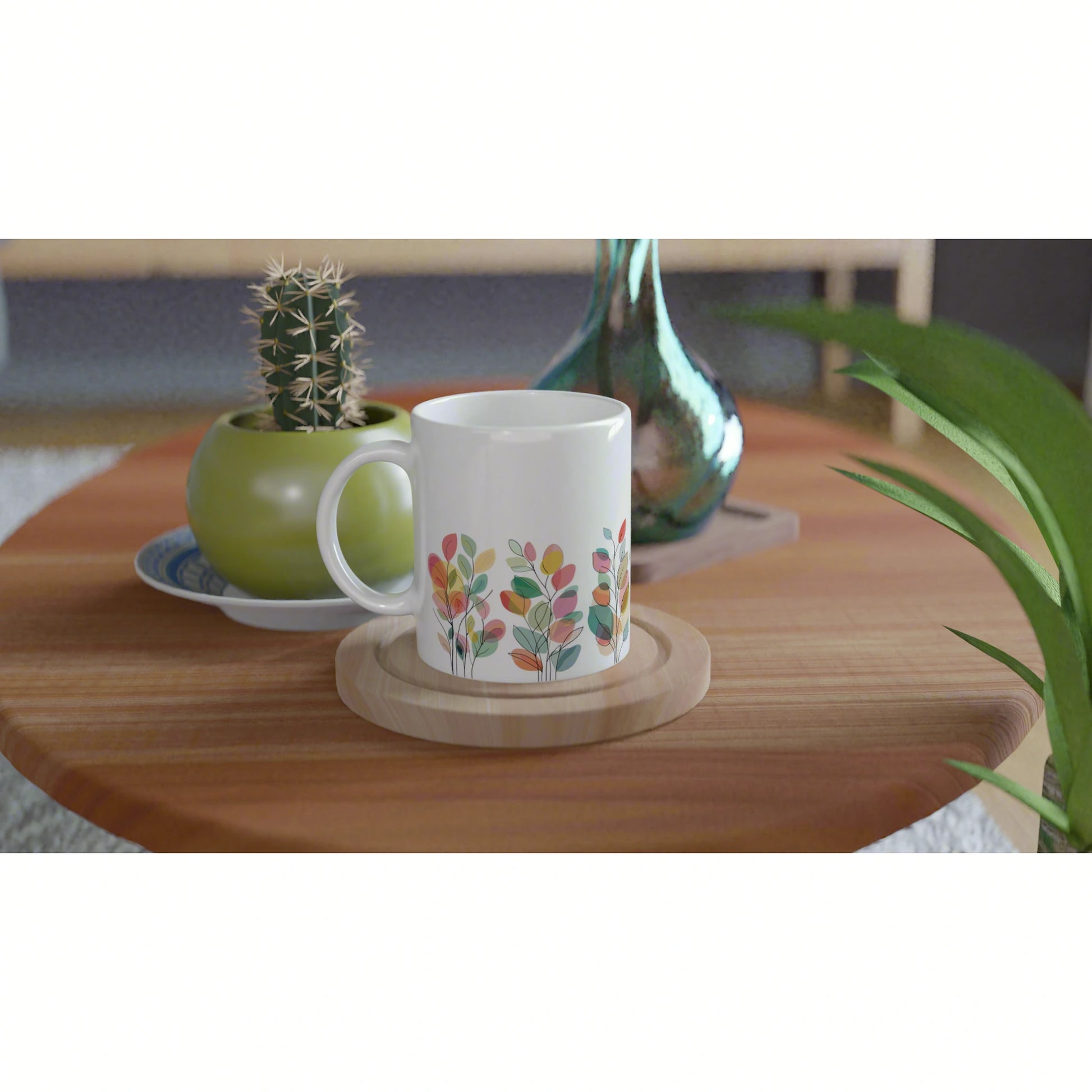 Product mockup: white mug with colorful leafy pattern on a wooden coaster atop a coffee table.
