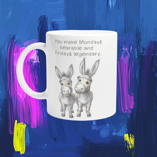 White mug with a pencil sketch of two donkeys and the caption 'You make Mondays bearable and Fridays legendary' — mockup.
