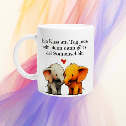 White mug mockup featuring two cartoon elephants kissing with a red heart and a German sunshine slogan.