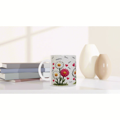 White mug with a vibrant daisy floral pattern and tiny hearts, set on a white desk beside stacked books and beige vases.