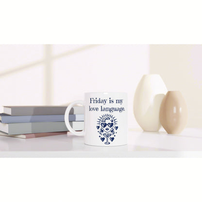 White mug with navy print Friday is my love language and graphic, set on a desk with books and minimalist vases.
