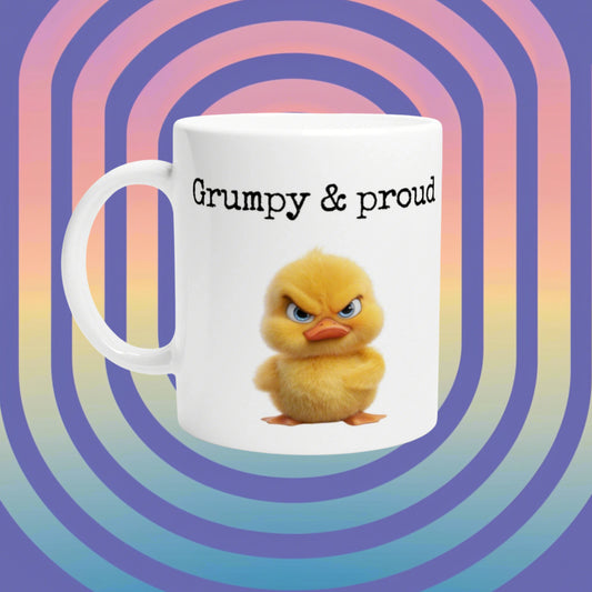 White mug with 'Grumpy & proud' text and a fluffy yellow duckling against a vibrant retro gradient backdrop.