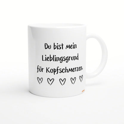 White mug with black handwritten German text Du bist mein Lieblingsgrund fuer Kopfschmerzen and a row of five heart doodles.