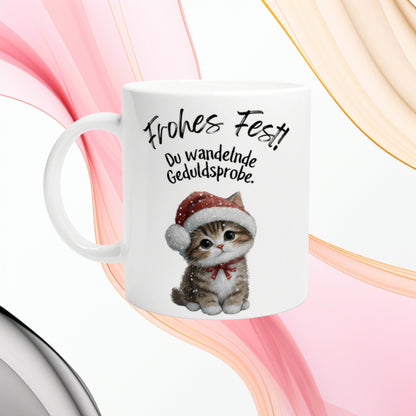 White mug with a cute kitten in a Santa hat and the German text Frohes Fest! Du wandelnde Geduldsprobe.