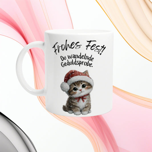 White mug with a cute kitten in a Santa hat and the German text Frohes Fest! Du wandelnde Geduldsprobe.
