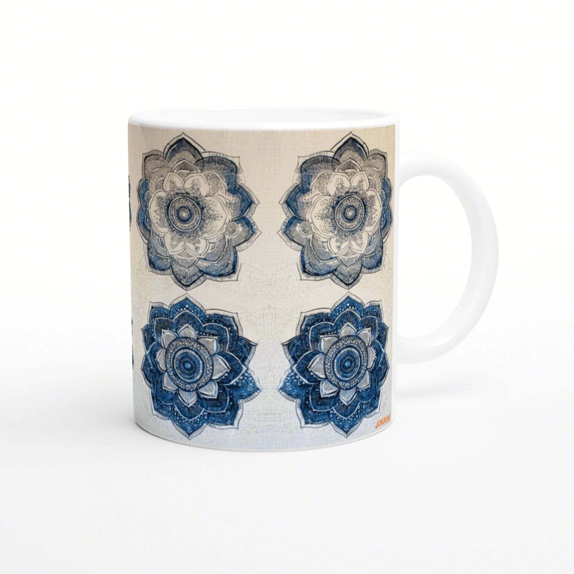White mug adorned with four mandala flowers in blue and beige, arranged in a grid; product mockup.