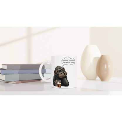 White mug mockup featuring a cartoon chimp holding a drink and thinking I should have more one-night stands with books.