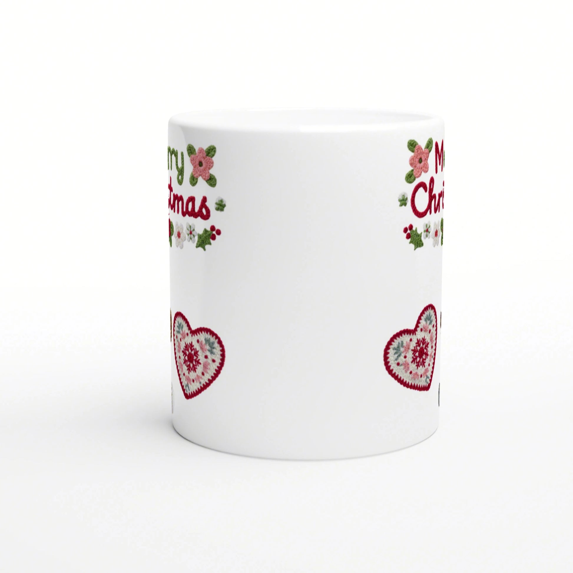White mug mockup with Christmas border: red crocheted hearts, holly, pink flowers, and partial red lettering near the rim.