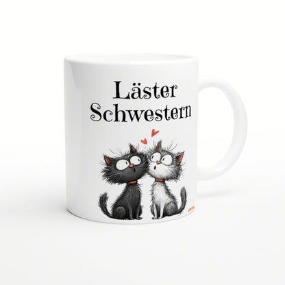 White mug mockup featuring two cartoon cats (black and white), red hearts, and the German phrase Läster Schwestern.