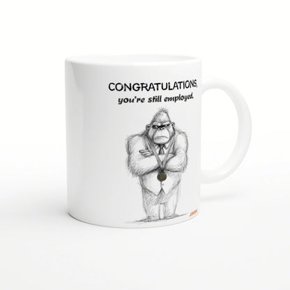 White mug mockup with a sketch of a gorilla in a suit wearing a medal and the caption CONGRATULATIONS, you're still employed.