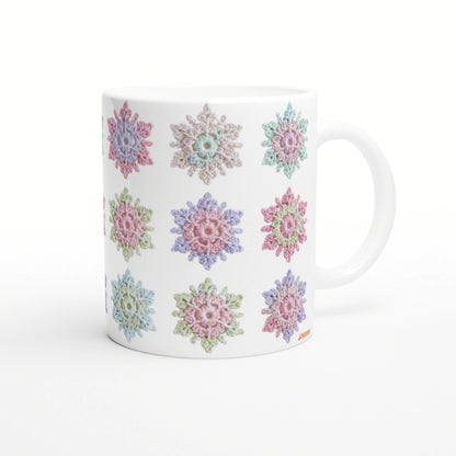 White ceramic mug featuring pastel crochet-style flower motifs around its surface; product mockup.