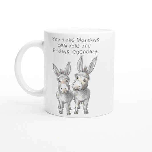 White mug with a pencil sketch of two donkeys and the phrase 'You make Mondays bearable and Fridays legendary'.