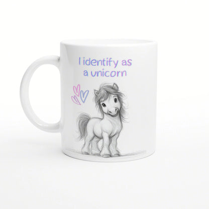 White mug mockup featuring a pencil-drawn pony, pastel hearts, and the slogan 'I identify as a unicorn'.