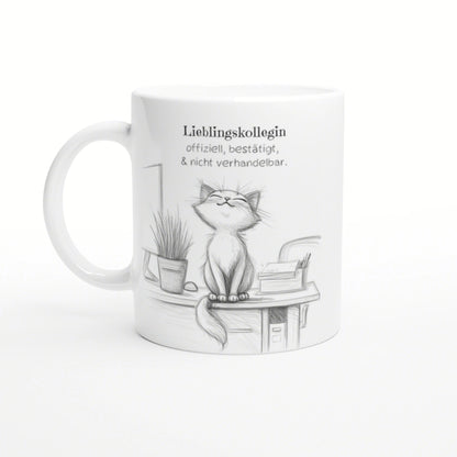 White mug featuring a pencil sketch of a happy cat perched on a desk with a plant and books; German caption about a favorite colleague.