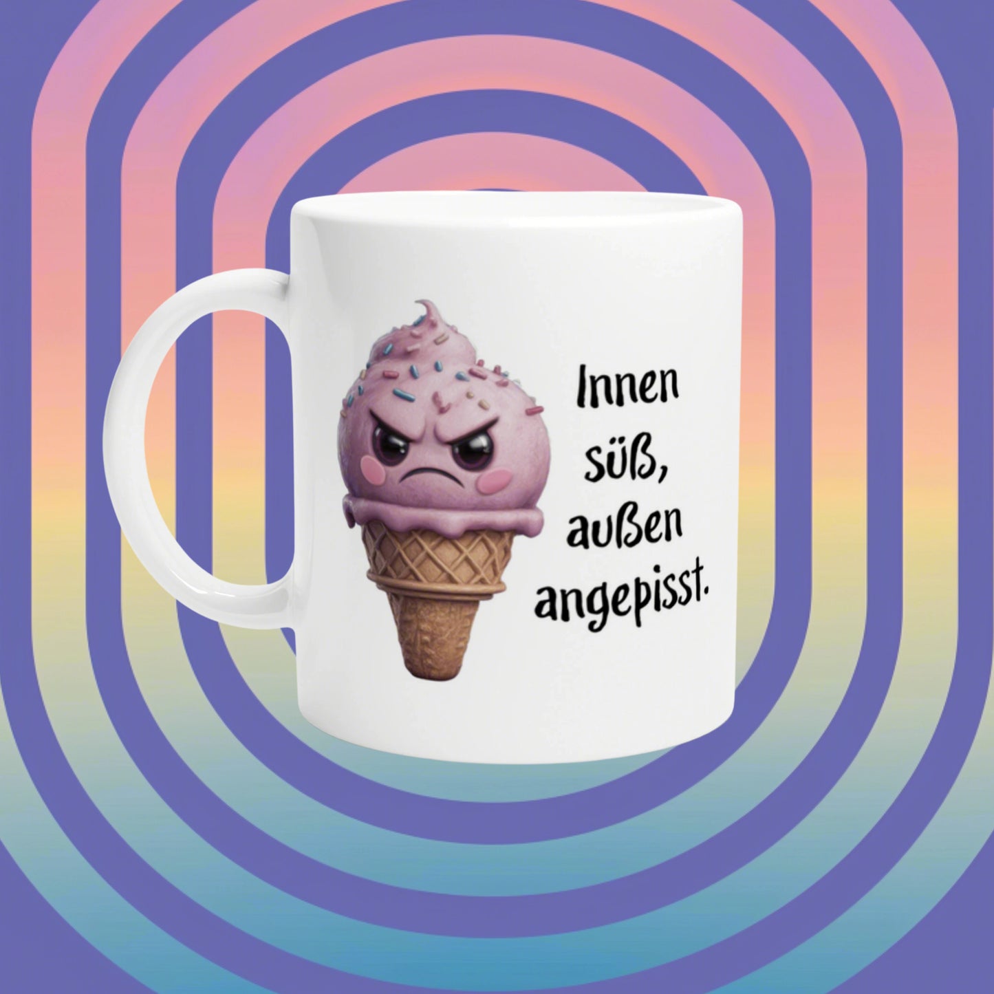 White mug featuring a pink ice-cream cone with an angry face and the German slogan Innen süß, außen angepisst on a pastel rainbow background.