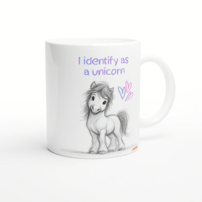 White mug with a pencil sketch of a pony and the pastel phrase I identify as a unicorn, plus pink and purple hearts.