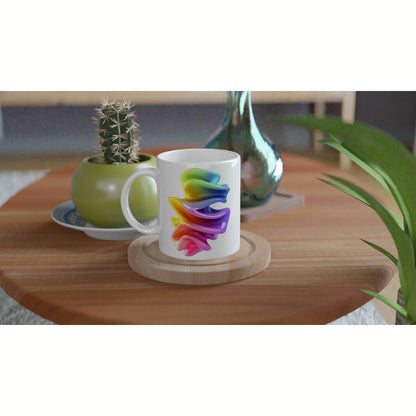 White mug with rainbow swirl design on a wooden coaster, placed on a wooden table with green plants in the background.