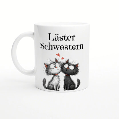 White mug mockup showing two cartoon cats facing each other with hearts and the caption Läster Schwestern.