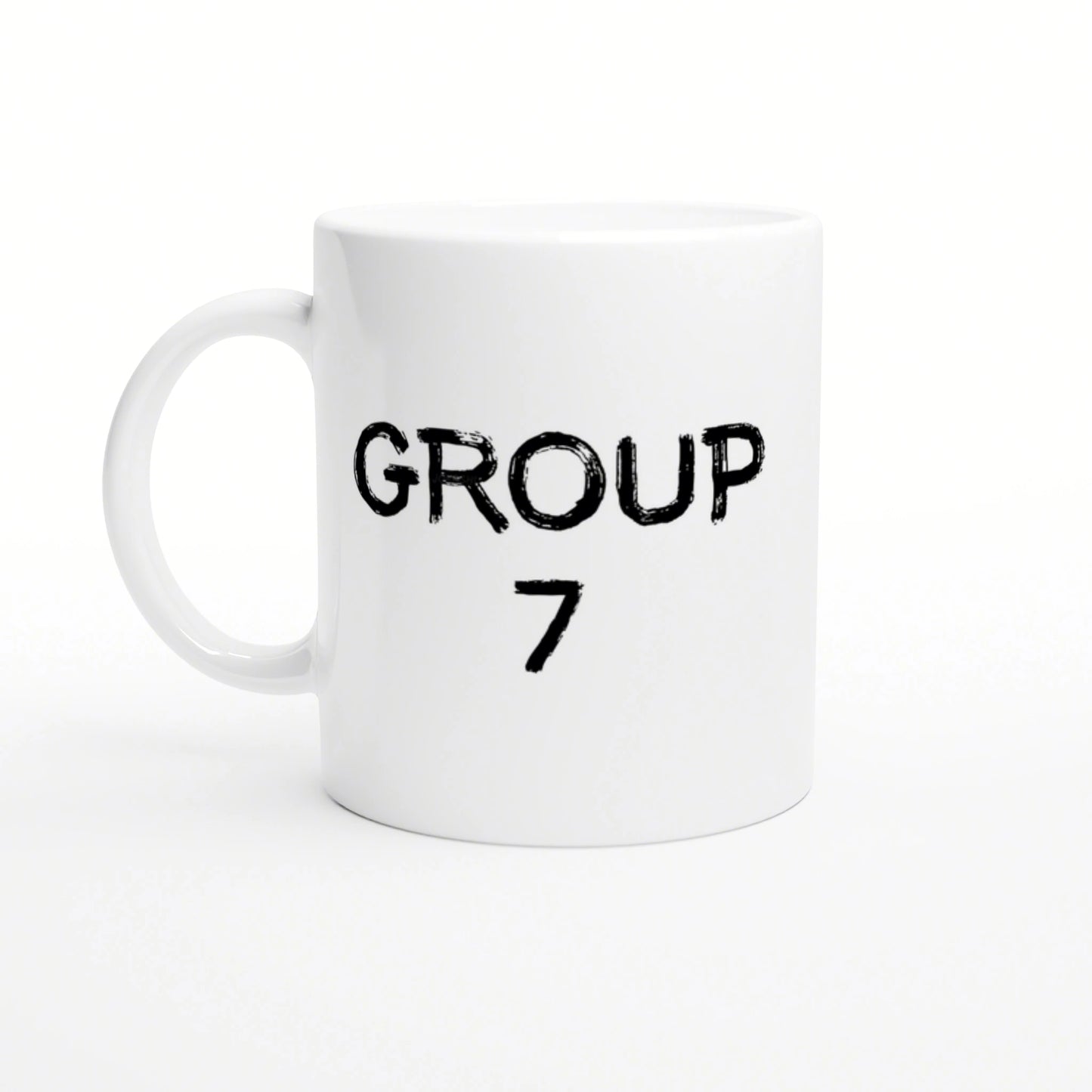 White ceramic mug featuring two-line black distressed text: 'GROUP' on top and '7' below, on a plain white studio background.