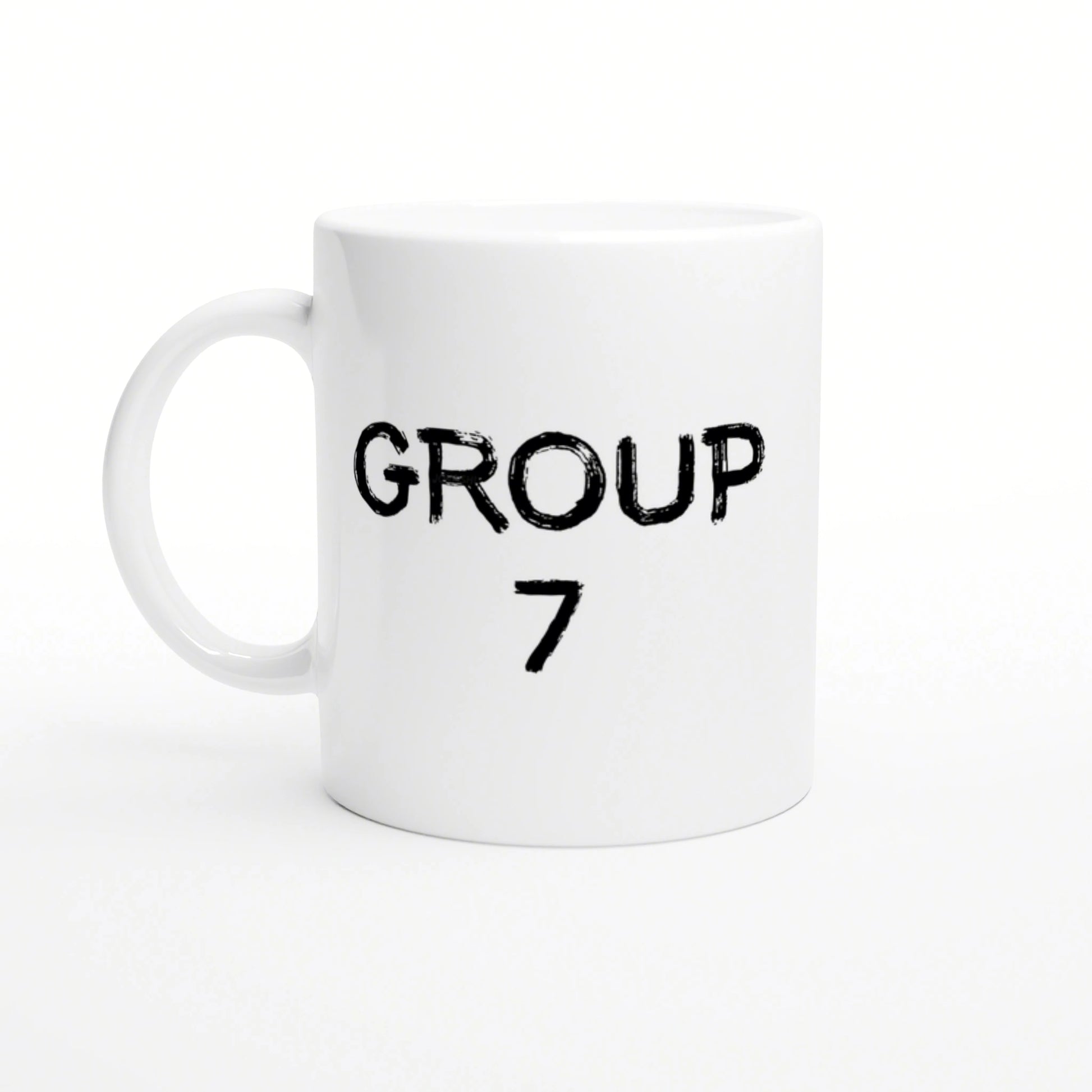 White ceramic mug featuring two-line black distressed text: 'GROUP' on top and '7' below, on a plain white studio background.