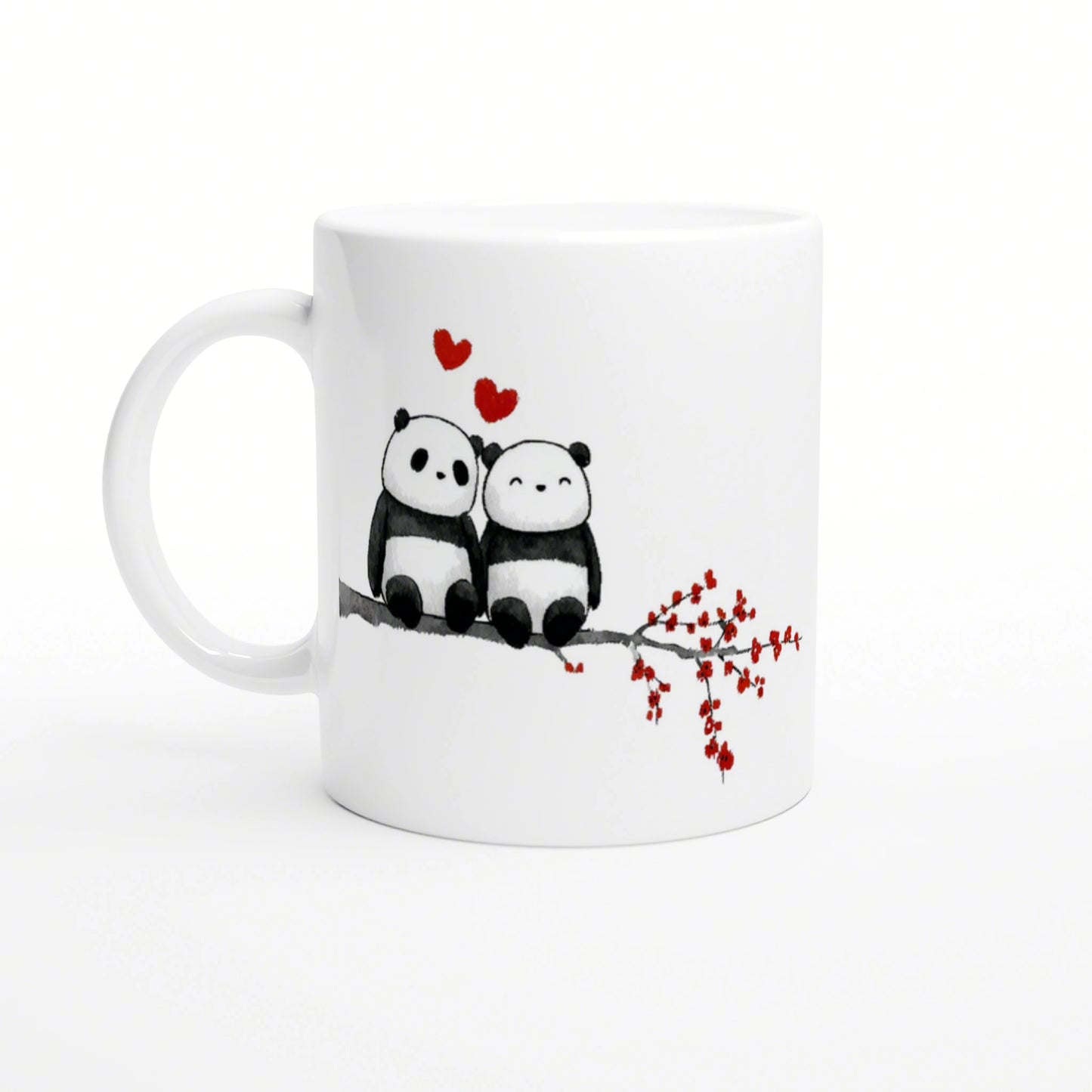 White mug featuring two cuddling pandas on a branch, with red hearts above and a red-flowered twig to the side.