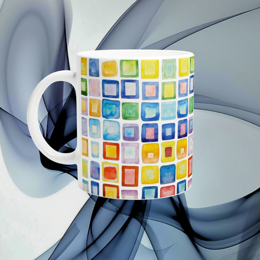 White mug with a vibrant grid of multicolored squares; product mockup for an online cup and shirt store.