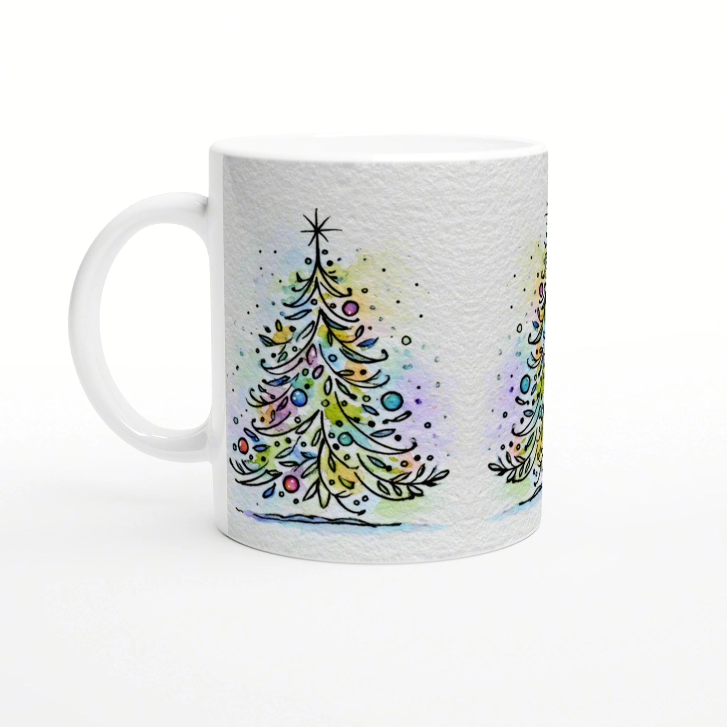 White mug with a wraparound watercolor Christmas tree design and colorful ornaments on a pale background.