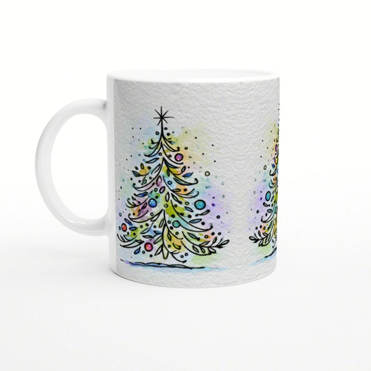 White mug with a wraparound watercolor Christmas tree design and colorful ornaments on a pale background.