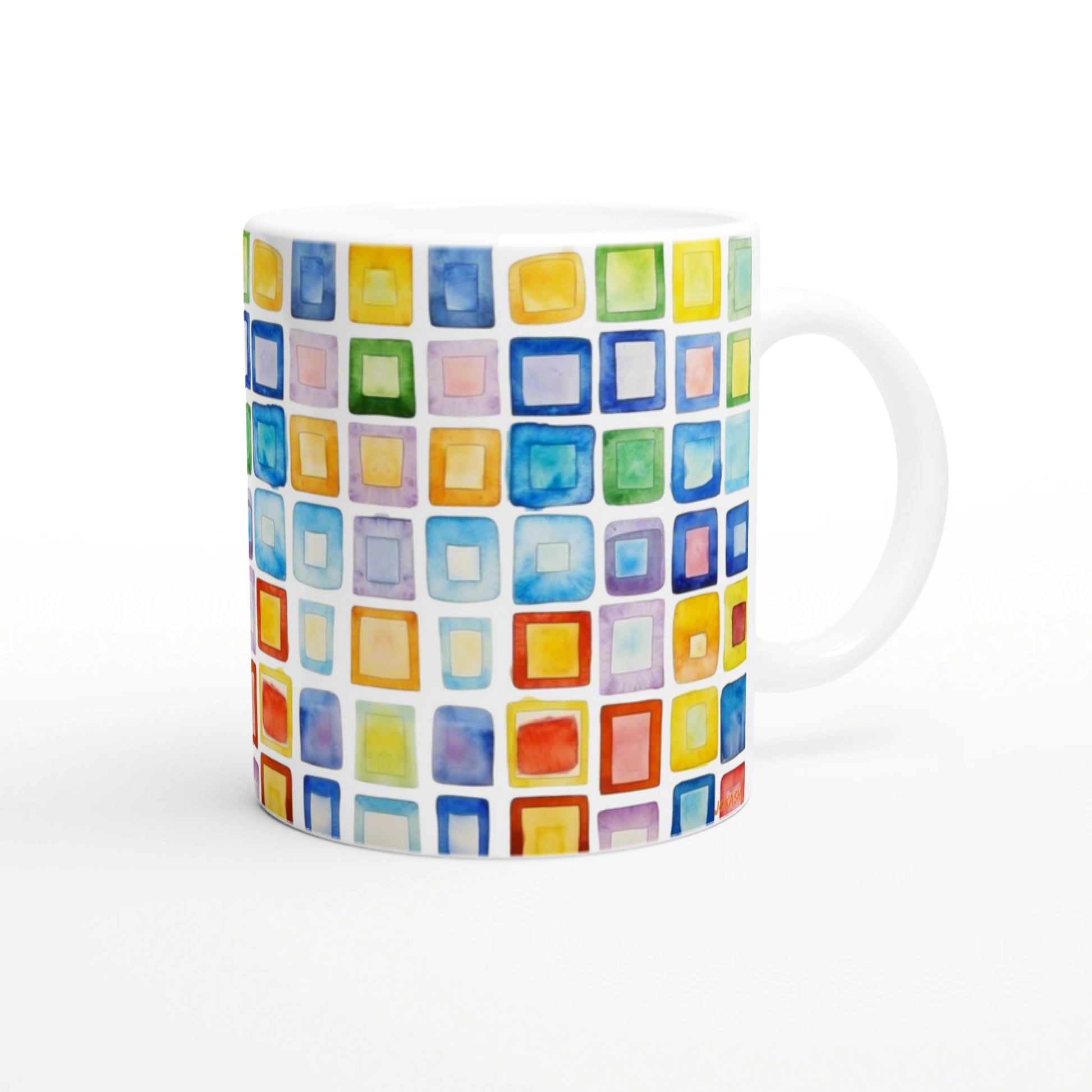 White ceramic mug with a vibrant grid of multicolored watercolor squares wrapping around its surface.