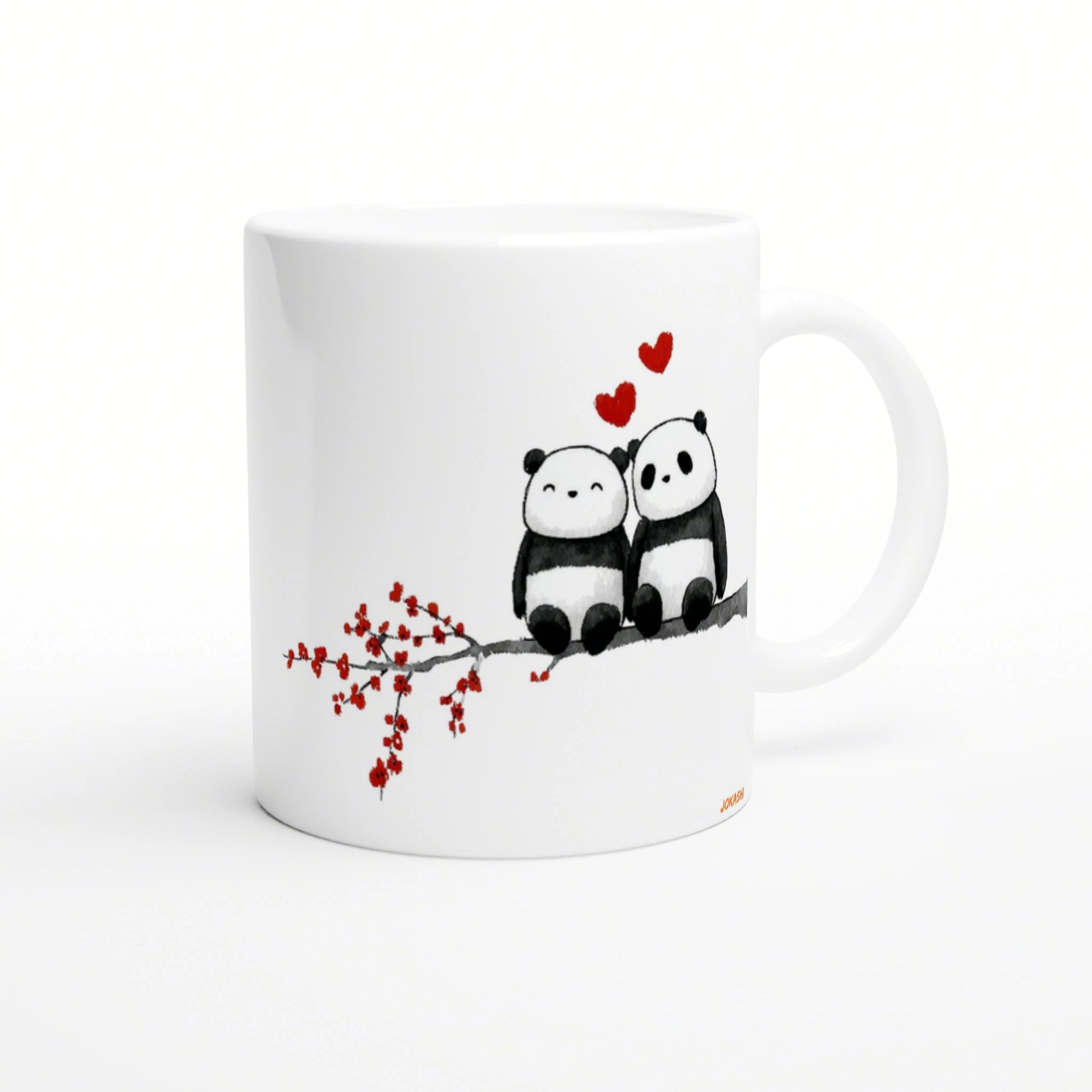 White mug with a watercolor illustration of two pandas on a branch, red hearts above.
