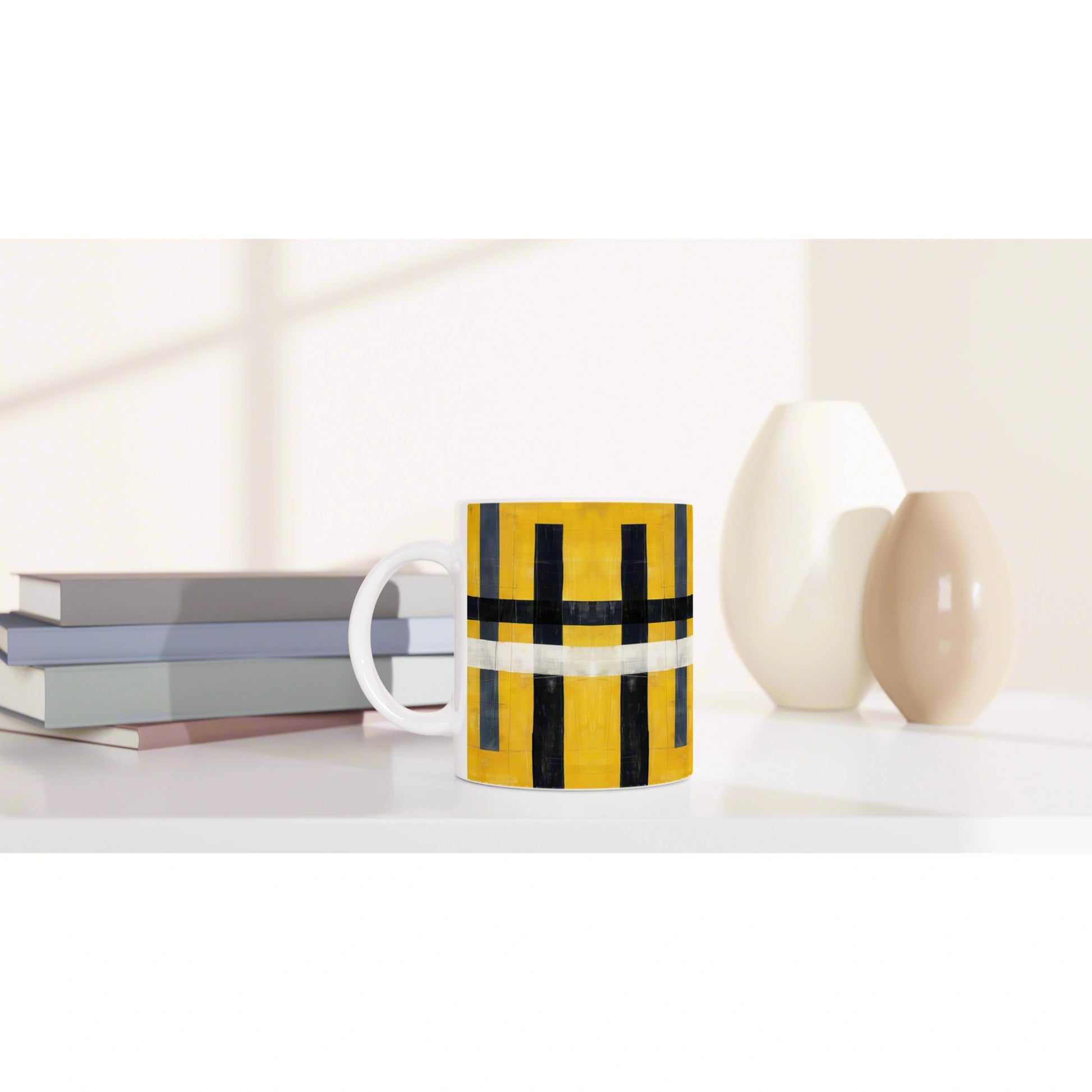 Mug with yellow and black geometric pattern on a white surface, with books and ceramic vases in a minimalist product mockup.